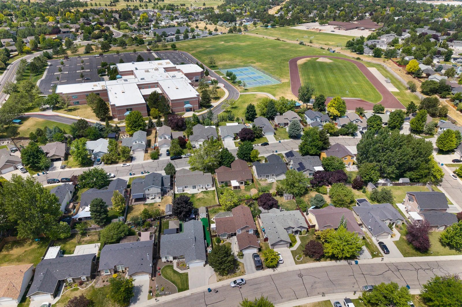 High aerial view of a neighborhood, school, and track