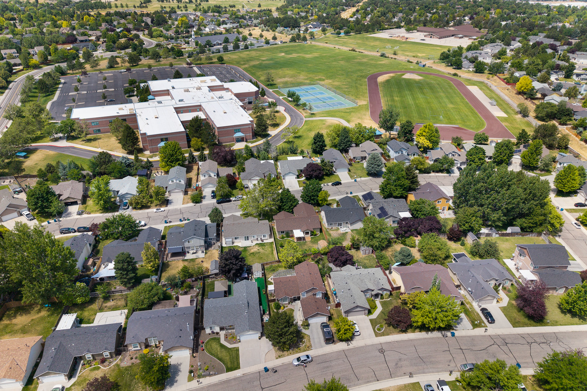 High aerial view of a neighborhood, school, and track