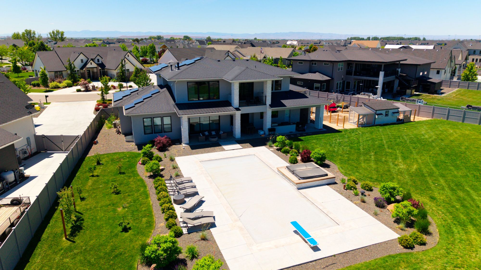 Aerial view of a luxury home with pool, hot tub, and landscaped backyard